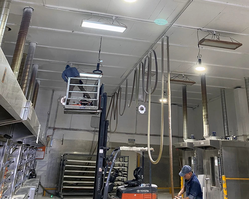 LED high bay light fittings being installed inside a bakery by an electrician