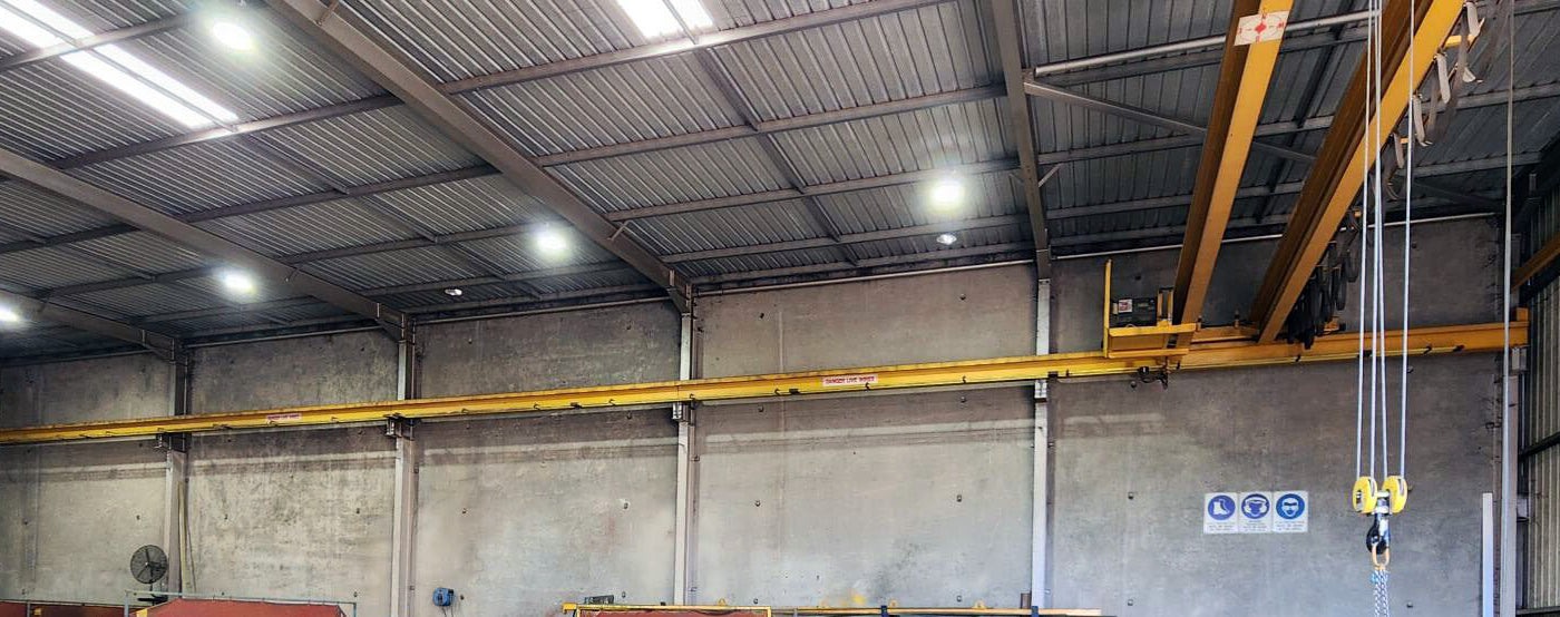 LED high bay lights installed inside industrial steel workshop