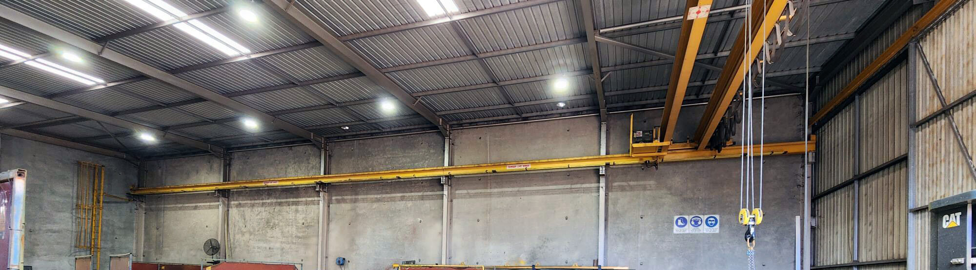 LED high bay lights installed inside industrial steel workshop