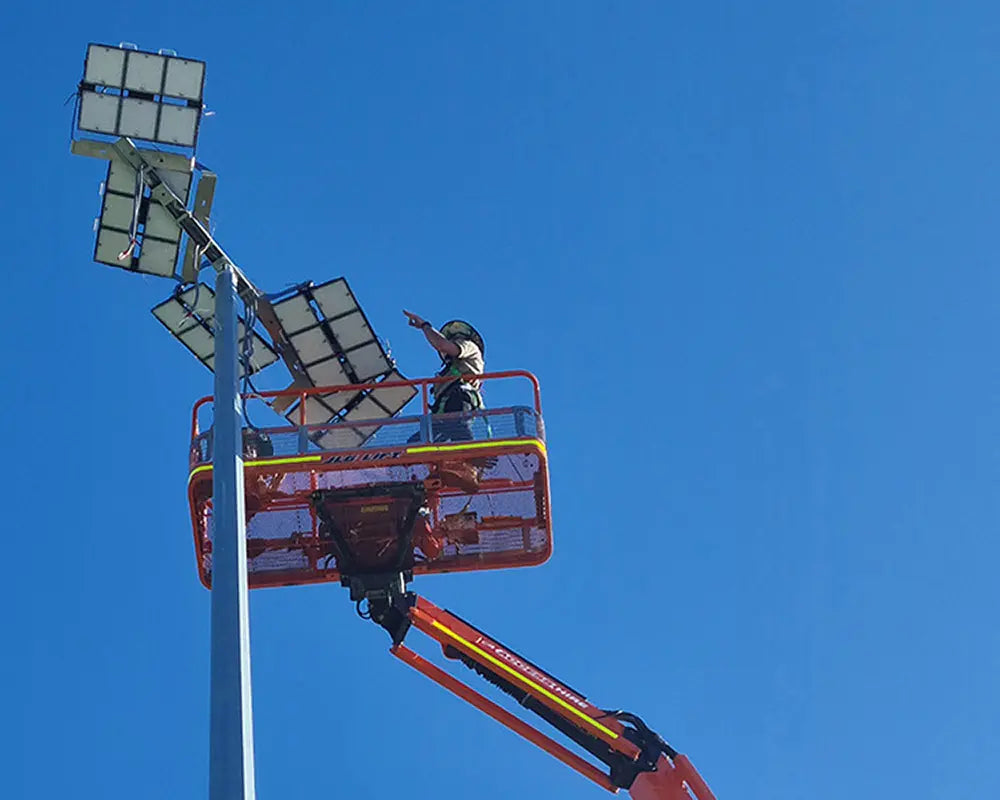 LED high mast light fittings being installed on a pole by an electrician
