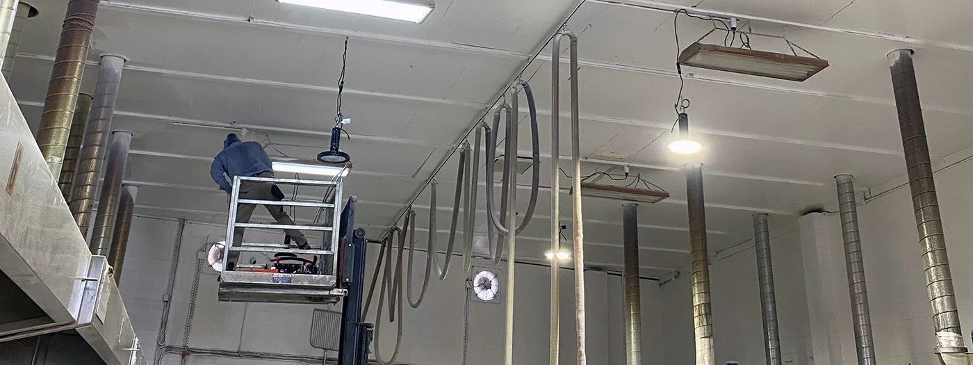 LED high bay light fittings being installed inside a bakery by an electrician