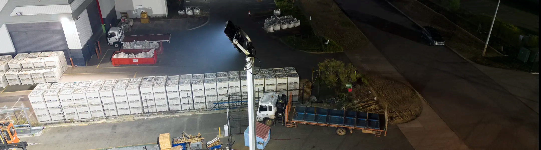 High mast LED flood light illuminating an industrial truck loading bay at night