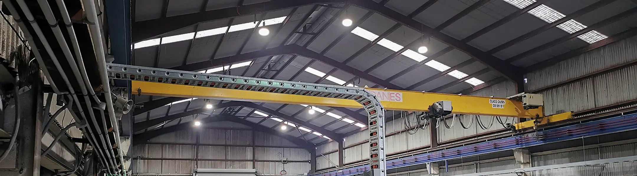 LED high bay lights illuminating an industrial machinery workshop